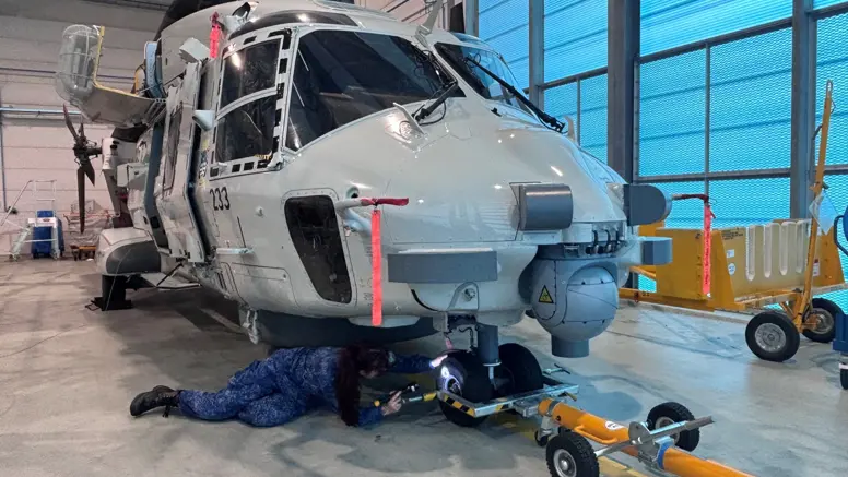 Matroos 1 Technische Dienst Jaimie inspecteert het neuswiel van een NH90.