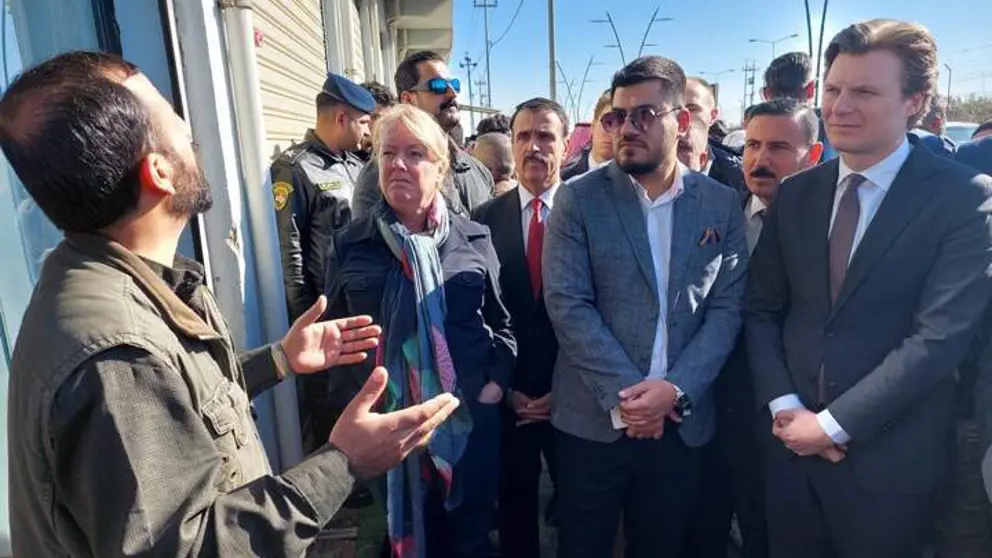 De minister luistert in Irak naar een man.