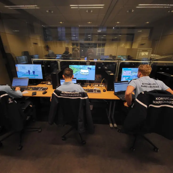 Drie marechaussees in opleiding zitten achter de PC om te trainen met de IBT-game.