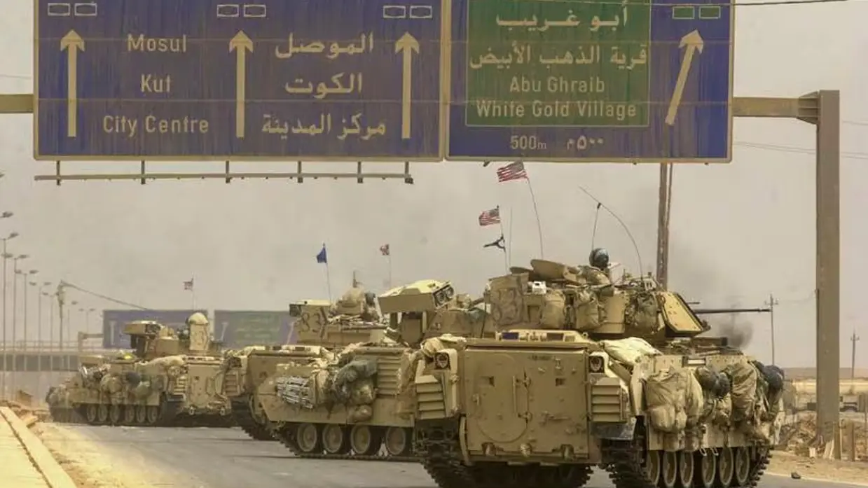 Links: Een rij militaire pantservoertuigen rijdt op weg naar Bagdad. Boven de weg staan verkeersborden met Mosul, Abu Ghraib en White Gold Village. Er zijn vlaggen te zien in een stoffig landschap. Rechts: Een pantserwagen staat op een stoffig, open veld. Op de achtergrond stijgt een dikke, zwarte rookkolom omhoog. Soldaten en uitrusting zijn zichtbaar rondom het voertuig.