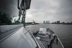 Marineschip vaart haven van Rotterdam binnen.