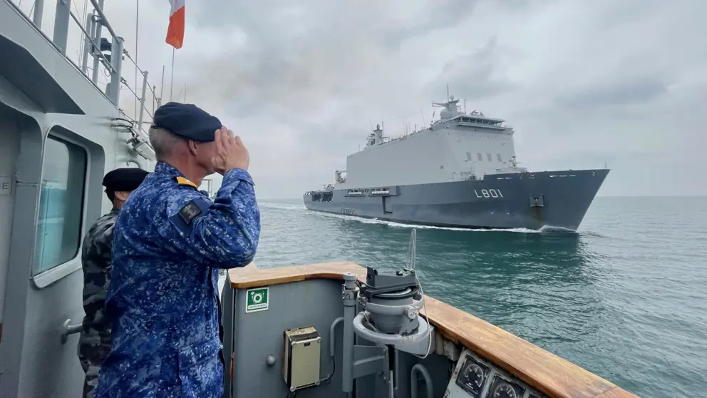 Warnaar saat op het Ierse schip en groet zijn schip dat voorbij vaart.