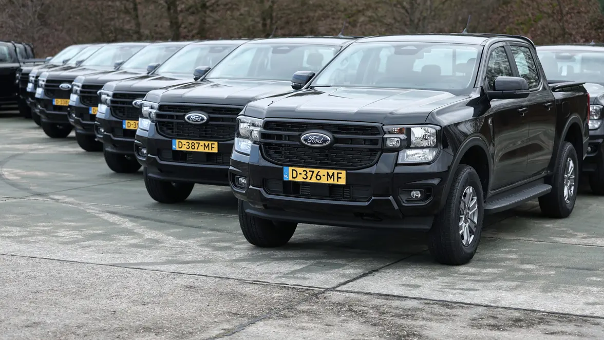 Op rij geparkeerde zwarte vierwiel-aangedreven voertuigen.