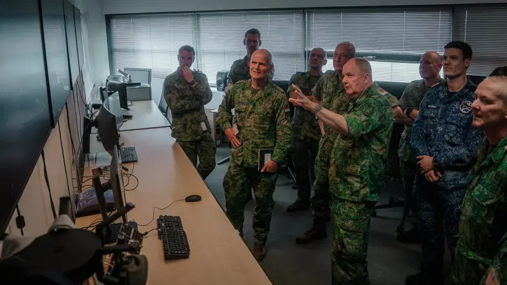 Militairen kijken naar verschillende beeldschermen.