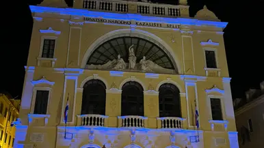 Een geel gebouwd in het donker, met paarse accenten.