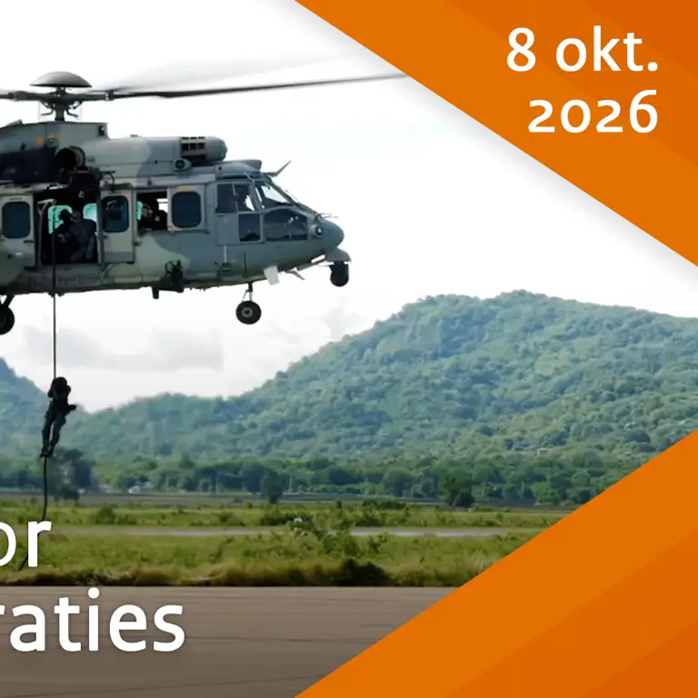 Een helikopter vliegt laag om cargo te vervoeren.