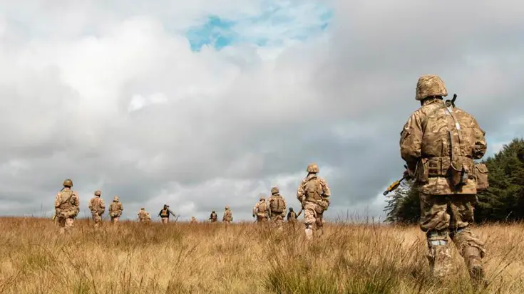 Militairen lopen door open veld.