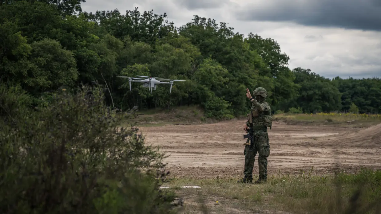 Militair begeleidt een drone tijdens inzet in het veld.