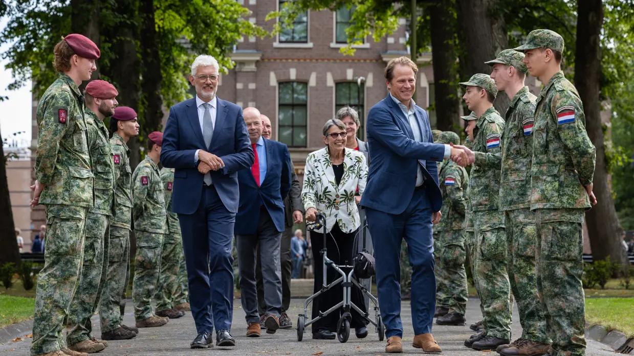 Gijs Tuinman schudt de hand van militairen. 