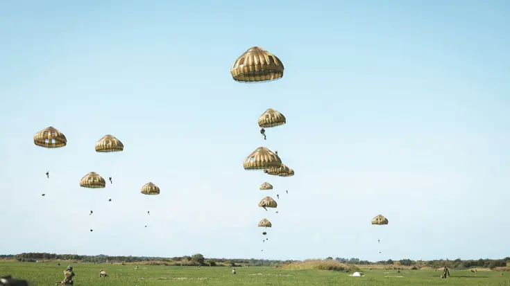 Een tiental parachutisten in de lucht