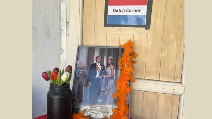 Foto van de koning en koningin met een vaas tulpen, met daarboven een bordje met: Dutch Corner, op een tafeltje in Irak. 