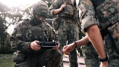 Nederlandse en Duitse militairen bestduren samen de bediening van een drone. 