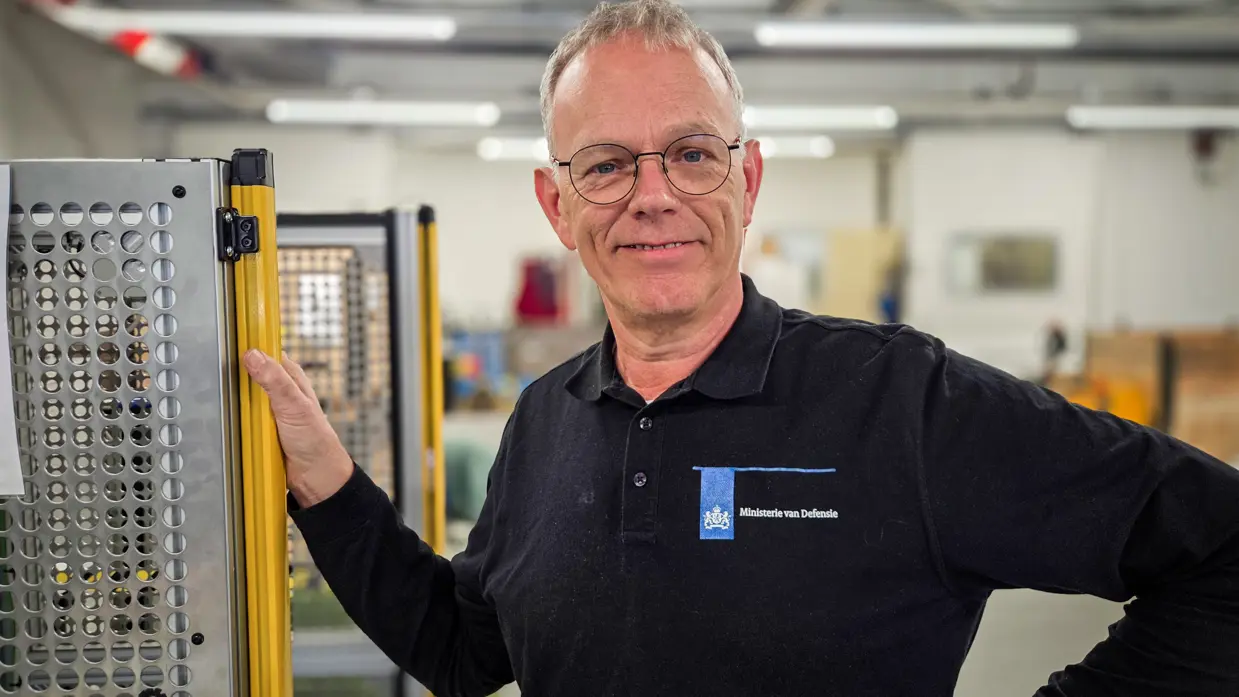 “Het is erg leuk werk en ik ben er ook trots op.”  Alt: Een portretfoto van Bert, coördinator van de veldmaskerwerkplaats van het KPU-bedrijf. 