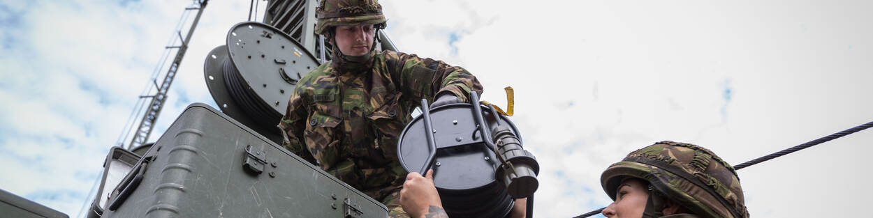 Twee militairen werken aan een helikopter.