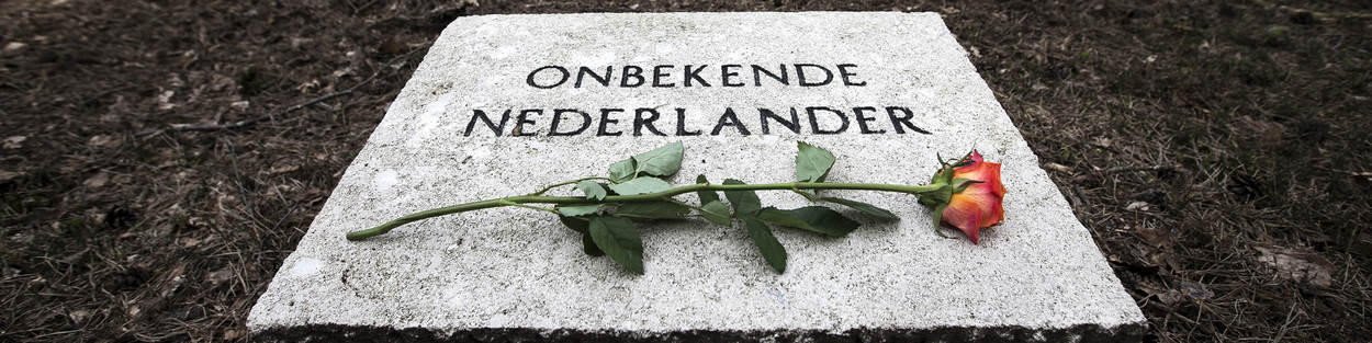 Grafsteen onbekende Nederlander met roos op Militair ereveld Loenen.