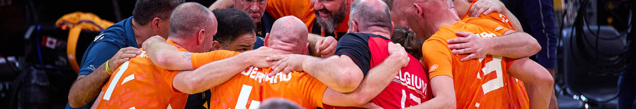 Het Nederlandse zitvolleybalteam moedigt zich aan in een kring.