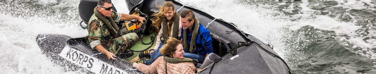5 personen varen in een rubberbootje van het Korps Mariniers.