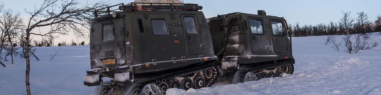Een Bandvagn rijdt door een besneeuwd Noors landschap tijdens een wintertraining van het Korps Mariniers.