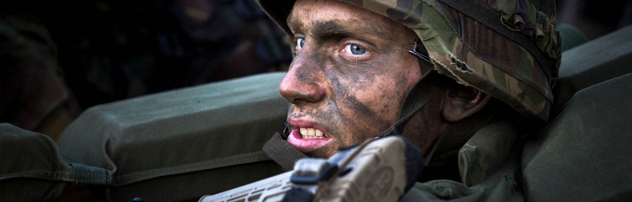 Close-up geschminkte militair met wapen.