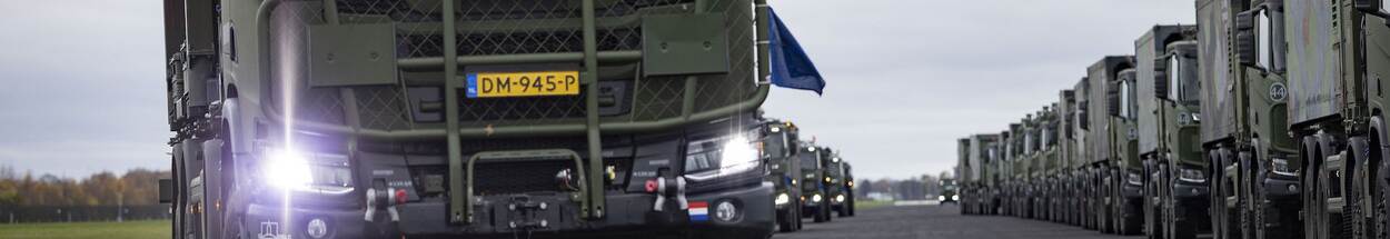 Rij met militaire vrachtwagens.