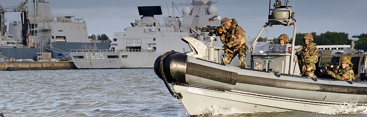Militairen varen in snelle motorboot in haven van Den Helder.