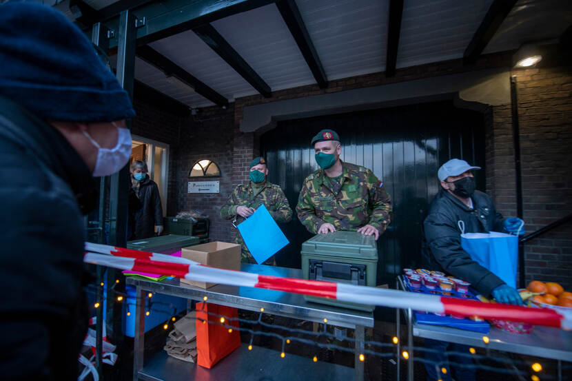 Militairen reiken maaltijden uit in Apeldoorn.