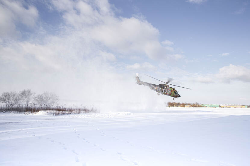 Militaire helikopter tijdens een white out  (opstuivende sneeuw).