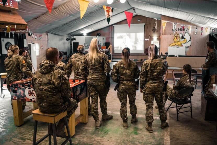 Nederlandse militairen kijken in Afghanistan naar een videoboodschap van minister Bijleveld.