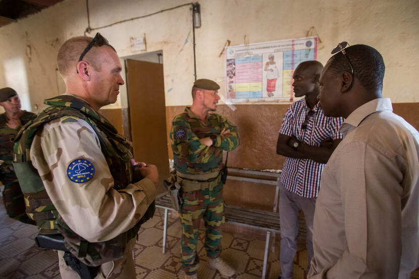 Militairen in gesprek met lokale bevolking.