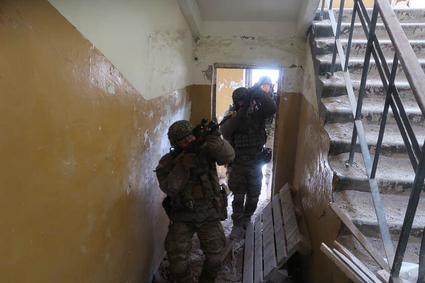 Militairen in de gang van een oud vervallen gebouw.