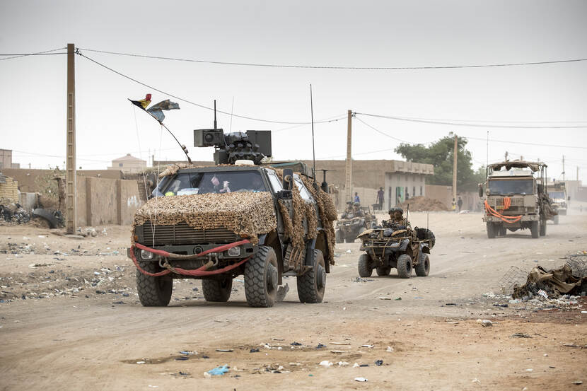 Een Belgisch voertuig rijdt over een zandweg in Mali, gevolgd door een quad met Nederlandse militairen.