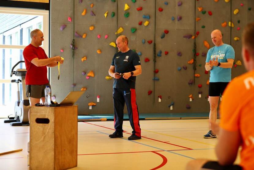 Generaal Onno Eichelsheim krijgt na het trainen in een sportzaal een medaille uitgereikt.
