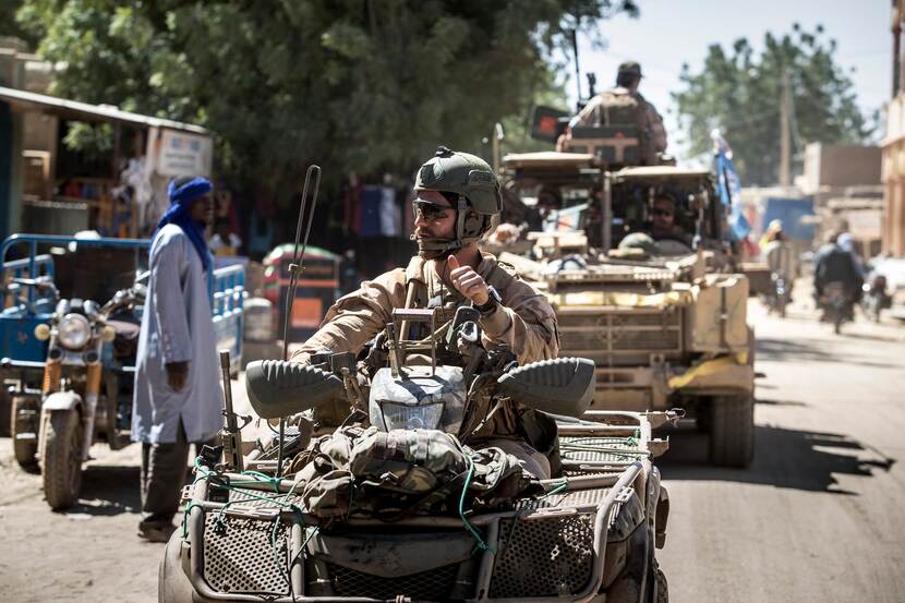 Militairen op quads in Mali. Voorste steekt zijn duim op.