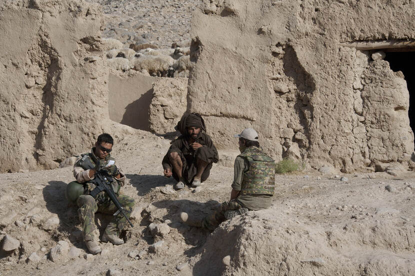Een Nederlandse militair spreekt met behulp van een tolk met een Afghaan in de provincie Uruzgan (juni 2010).