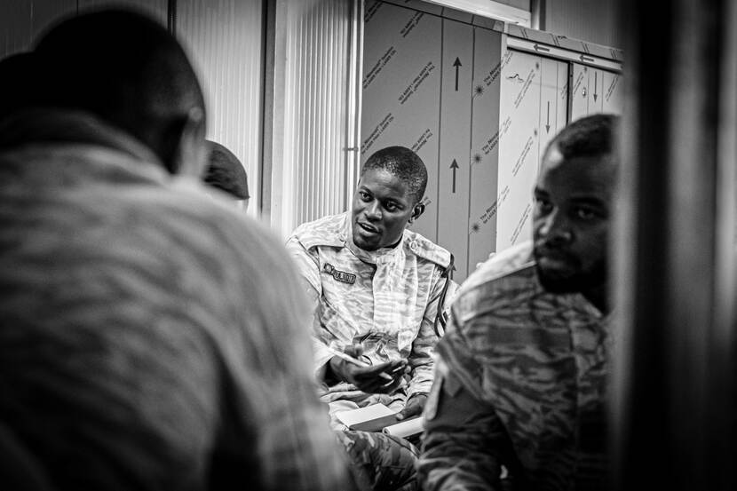 Zwart-wit-foto van militairen uit Burkina Faso en Ivoorkust tijdens de les van Nederlandse stafofficieren over Information Operations.