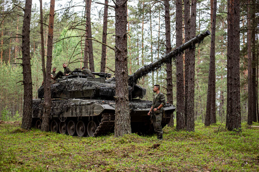 Militairen met tank in een bos in Litouwen.
