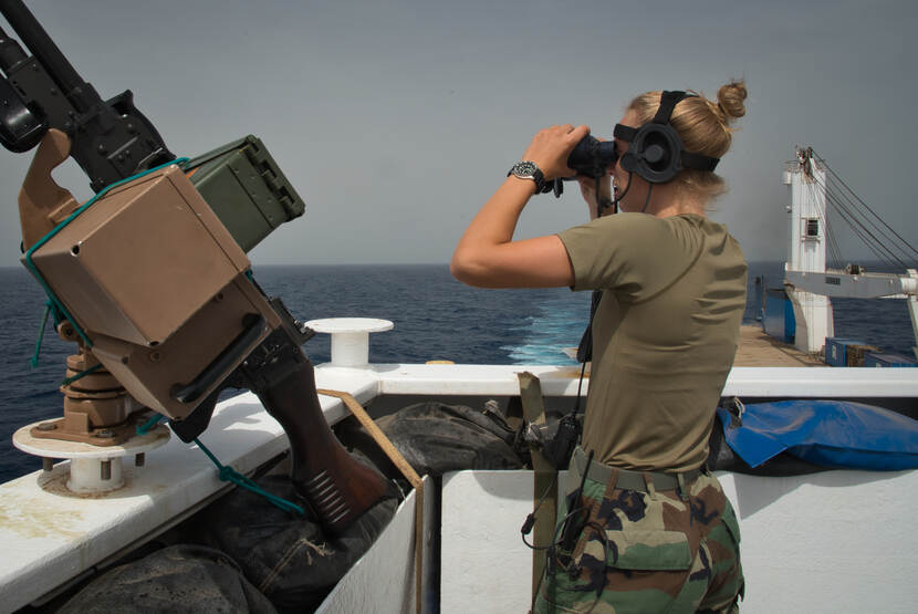 Een militair van het Fleet Marine Squadron staat op de uitkijk tijdens het beveiligen van een schip in de Golf van Aden.