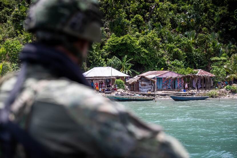 Een Nederlandse militair maakt contact met bewoners van Haiti.