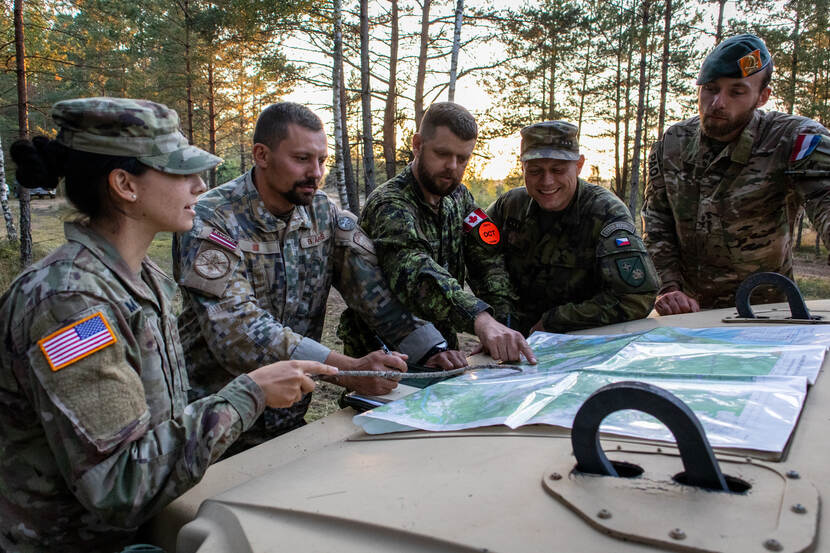 Militairen uit verschillende landen hebben een zogenoemd motorkapoverleg tijdens certificeringsoefening in Silver Arrow in Letland.