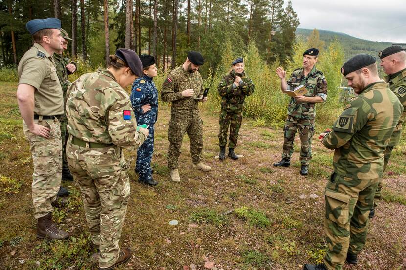 Deelnemers uit verschillende landen voeren overleg in het Zweedse bos tijdens Joint Protector.