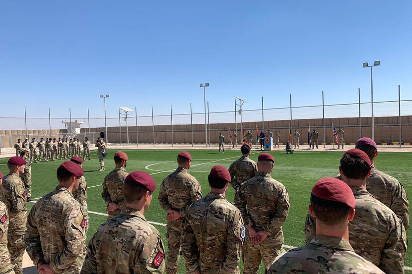 Nederlandse militairen in Jordanië staan opgesteld op een omheind voetbalveld.