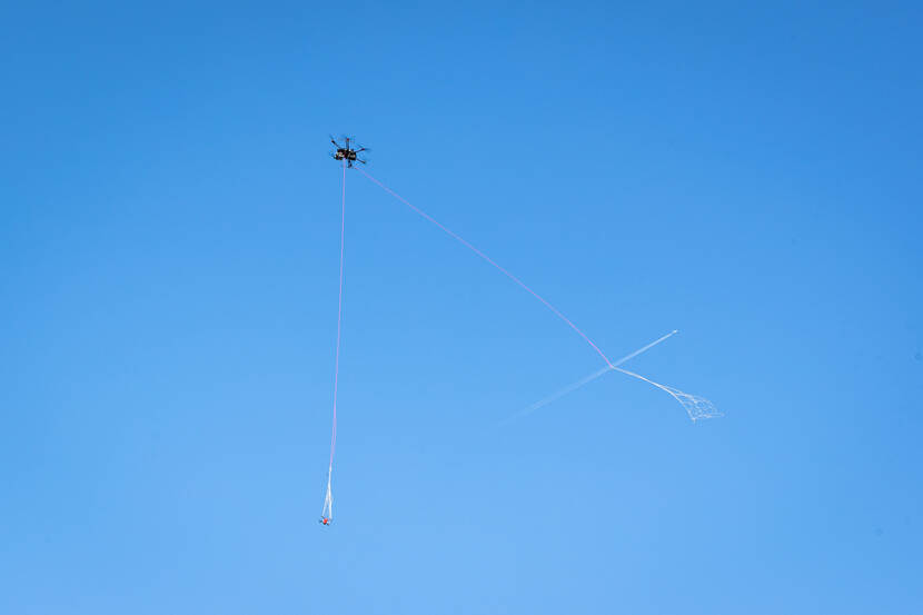 Drones en een net in de blauwe lucht.