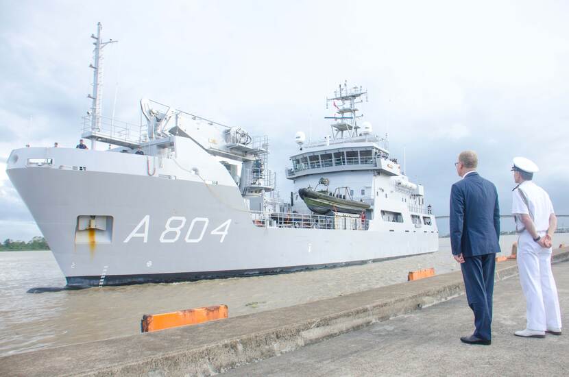 De Nederlandse ambassadeur wacht het marineschip op vanaf de kade.