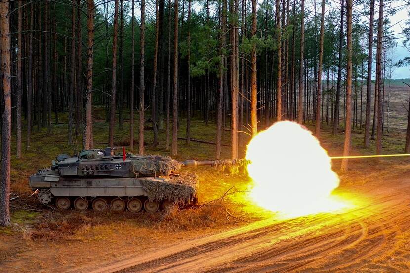 Tank in bos vuurt. Grote vuurbal aan voorzijde.