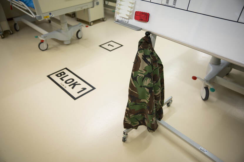 Camouflagejas hangt aan een informatiebord.