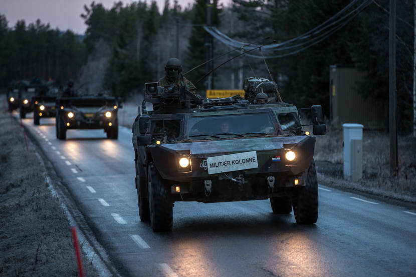 Kolonne militaire voertuigen over weg in Noorwegen. Trident Juncture 2018.