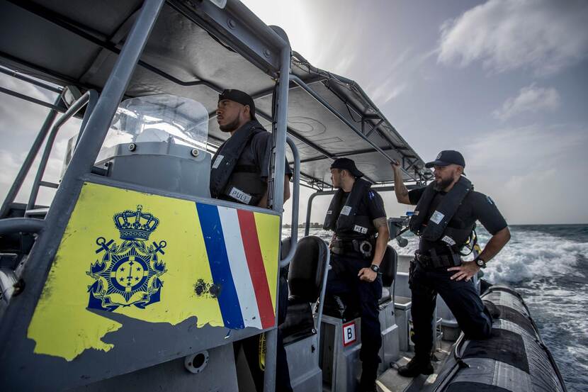 Militairen gaan aan boord van vaartuig ter controle.