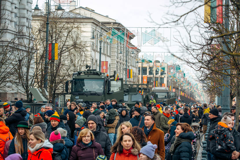 Straat in Litouwen, met veel burgers en militaire voertuigen.