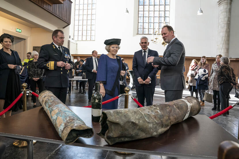 Mensen, onder wie prinses Beatrix, bekijken artefacten.