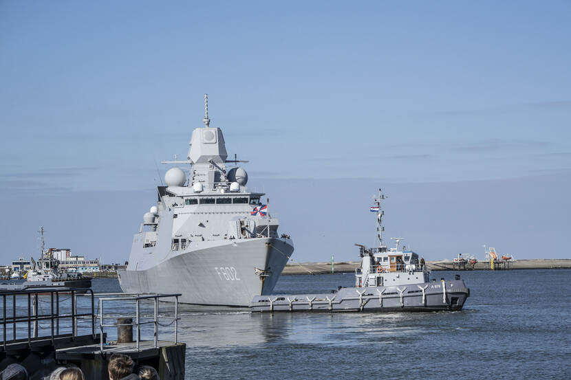 Zr.Ms. De Zeven Provinciën, met sleepboot op de voorgrond.